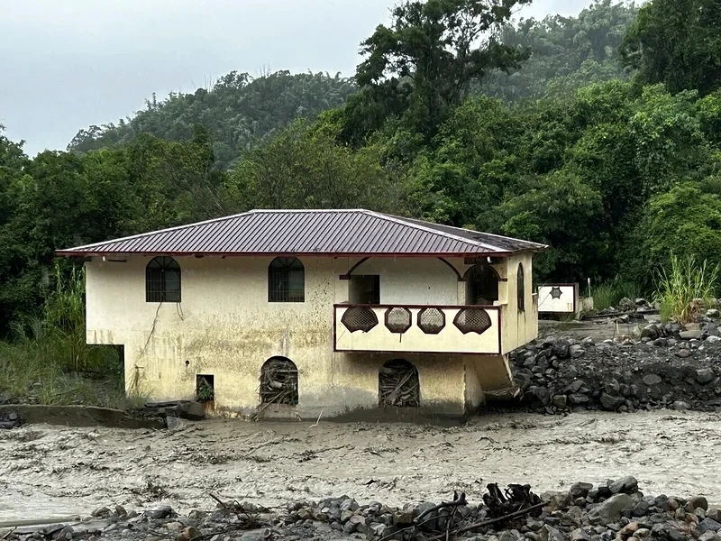 An unoccupied house beside sediment-filled Youkuang Creek in Jiasian District